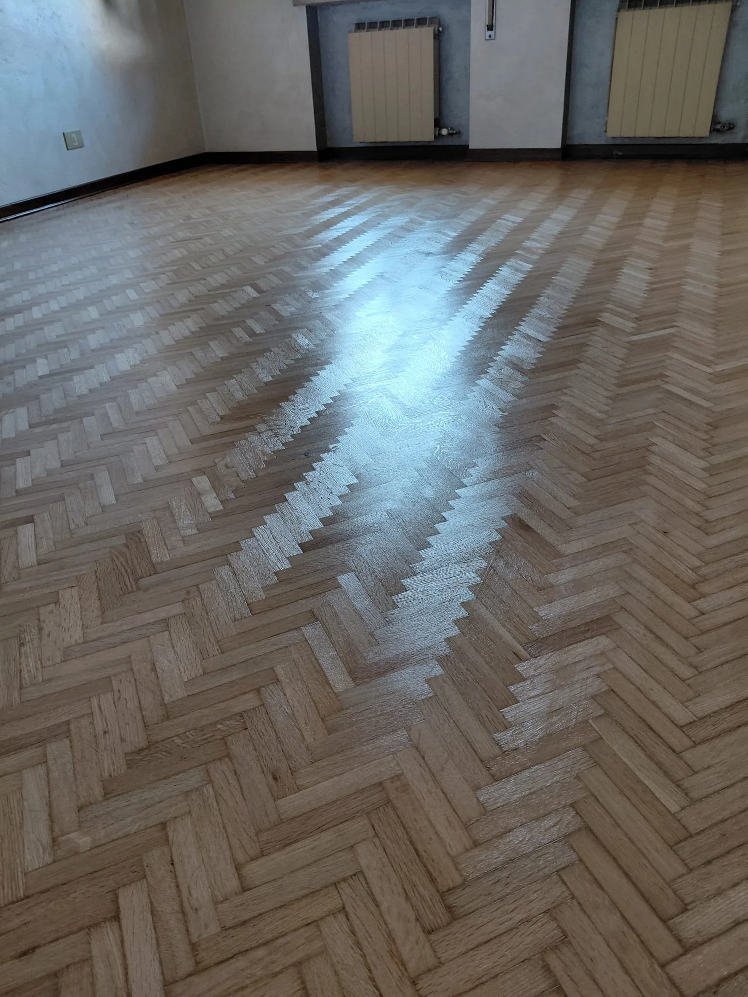 Grande sala con spina di pesce in rovere levigata e verniciata