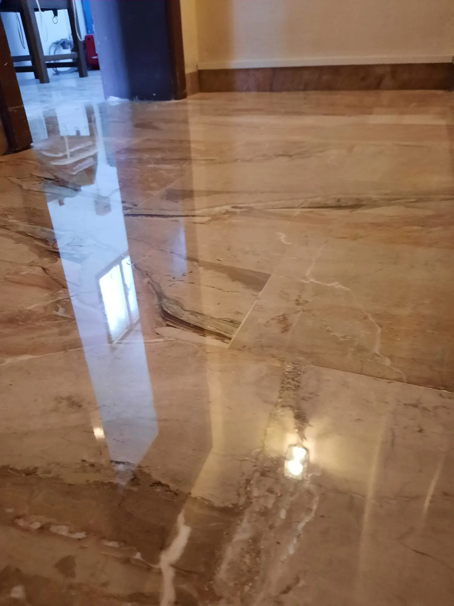 Marmo beige venato lucidato, con le luci di casa riflesse