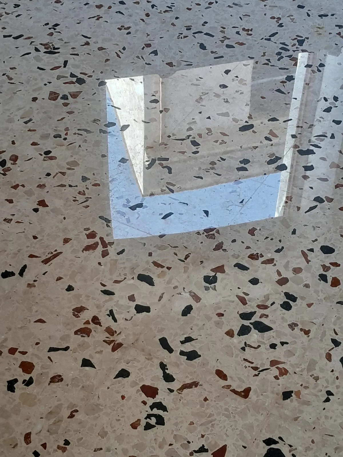 Terrazzo con scaglie nere e rosse riportato a lucido