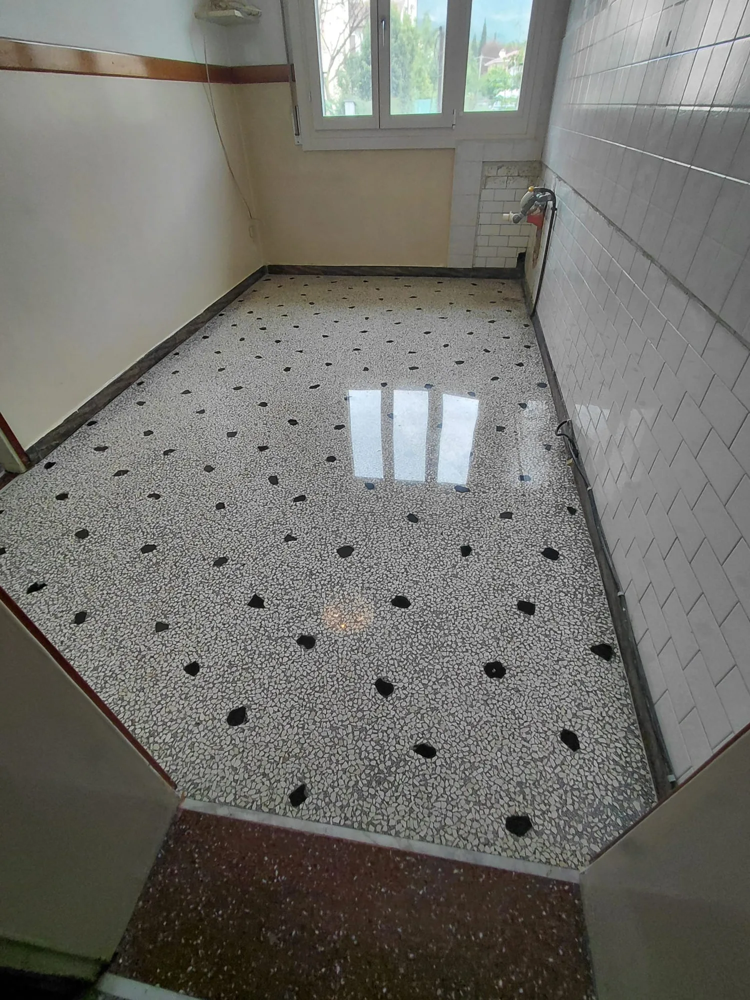 Terrazzo bianco con scaglie nere lucidato, in una cucina rimessa a nuovo