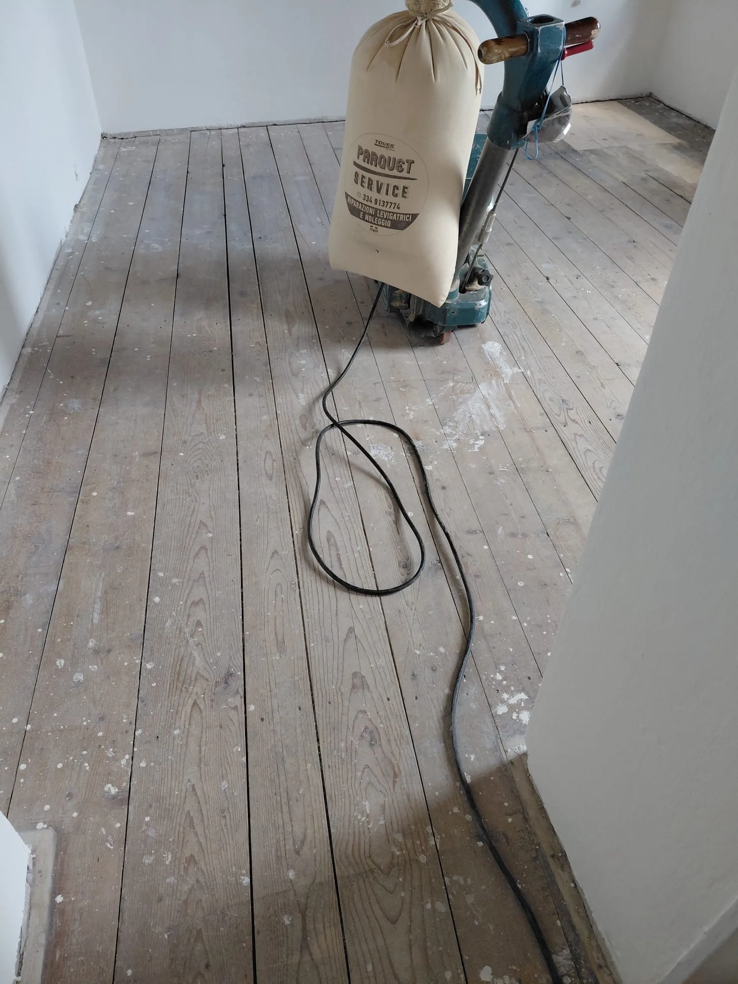 Monospazzola con aspiratore collegato su parquet appena levigato