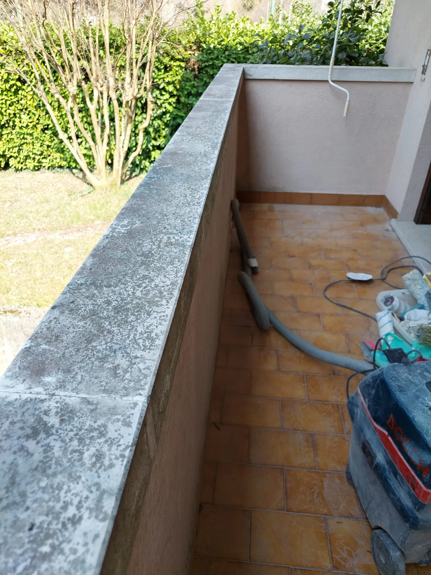 Copertina in pietra di un terrazzo, macchiata e ingrigita dalle intemperie